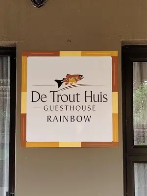 a sign on a wall with the words de trout huts guest houseyrinth rainbow at De Trout Huis Guesthouse in Dullstroom