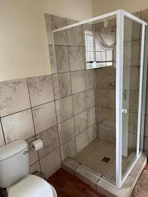 a bathroom with a shower with a toilet at De Trout Huis Guesthouse in Dullstroom