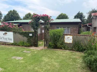 a house with a garden with a sign that reads do not disturb at De Trout Huis Guesthouse in Dullstroom
