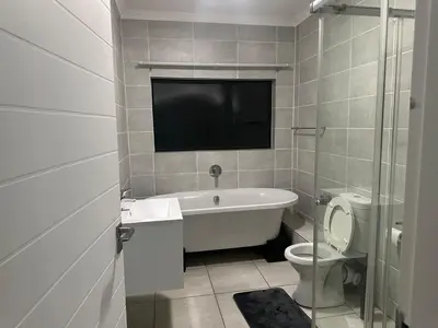 a bathroom with a tub and a toilet and a tv at The Blyde - Stay Iconic 2 bed Apartment in Pretoria