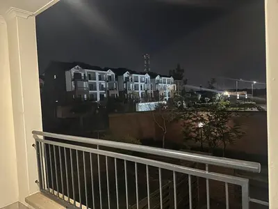 a view of a building at night from a balcony at The Blyde - Stay Iconic 2 bed Apartment in Pretoria