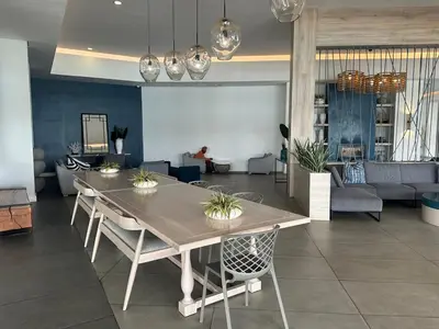 a dining table and chairs in a living room at The Blyde - Stay Iconic 2 bed Apartment in Pretoria