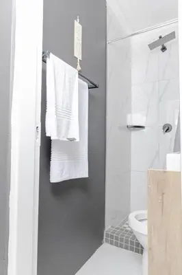 a bathroom with white towels hanging on a shower door at Milan Coproperties in Kempton Park