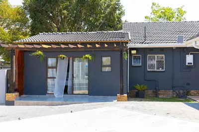 a blue house with a white curtain on it at Milan Coproperties in Kempton Park