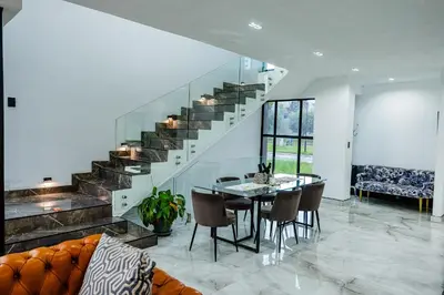 a dining room with a table and a staircase at Sucassa 54 - Luxury 2 Bedroom - Dam & Mountain View in Hartbeespoort