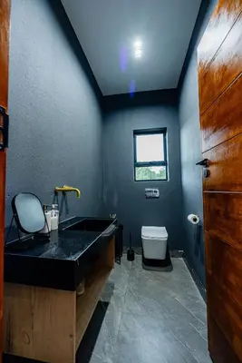 a bathroom with a black sink and a toilet at Sucassa 54 - Luxury 2 Bedroom - Dam & Mountain View in Hartbeespoort