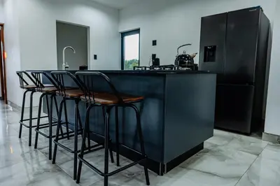 a kitchen with a black counter with stools around it at Sucassa 54 - Luxury 2 Bedroom - Dam & Mountain View in Hartbeespoort
