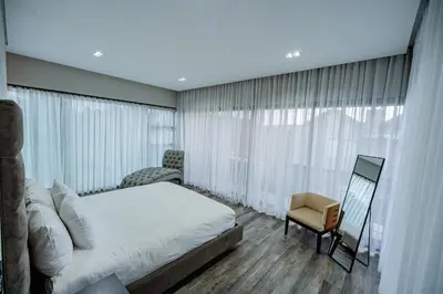 a bedroom with a large white bed and a chair at Sucassa 54 - Luxury 2 Bedroom - Dam & Mountain View in Hartbeespoort