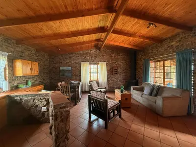 a living room with a couch and a table at Treeferns Trout Lodge in Dullstroom