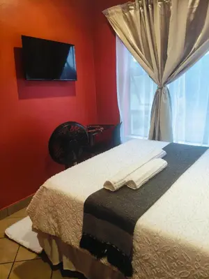 a bedroom with a bed with a television and a window at Express at Urban Cove in Nelspruit