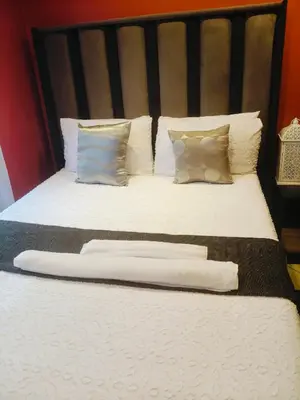 a bed with white pillows and a black headboard at Express at Urban Cove in Nelspruit