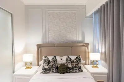 a bedroom with a bed with two lamps and two pillows at 932 menlyn maine in Pretoria