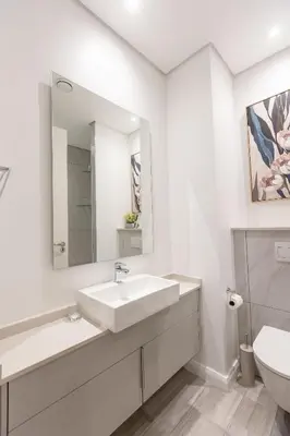 a white bathroom with a sink and a toilet at 932 menlyn maine in Pretoria
