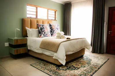a bedroom with a large bed with a teddy bear on it at 1 on Brandspruit in Secunda