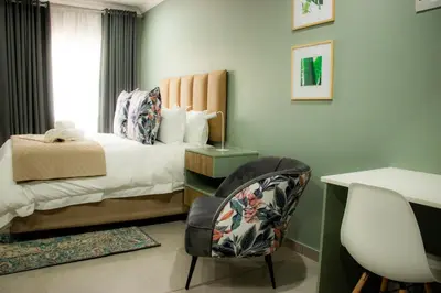 a bedroom with a bed and a desk and a chair at 1 on Brandspruit in Secunda
