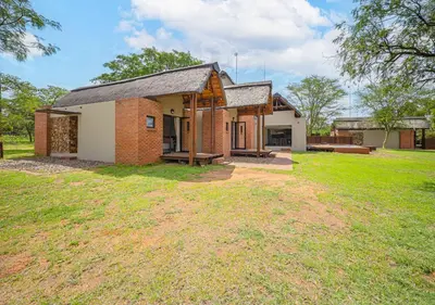 a small brick house with a grass yard at Bush Lodge Zebula 82 - 2 x 2B Chalets in Warmbaths