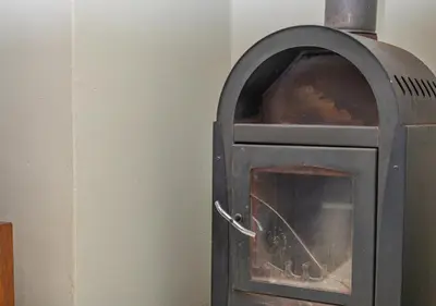 an old wood stove in a corner of a room at Bush Lodge Zebula 82 - 2 x 2B Chalets in Warmbaths