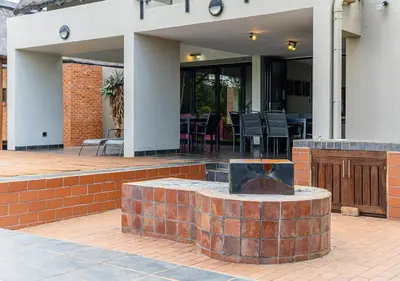 a brick fountain in the middle of a patio at Bush Lodge Zebula 82 - 2 x 2B Chalets in Warmbaths
