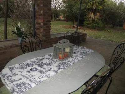 a table with a lantern sitting on a patio at Dandelion Cottage in Boschkop
