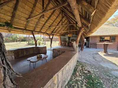a large wooden pavilion with a table and a table at LoWes Africa in Vaalwater