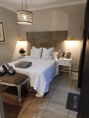 a bedroom with a large white bed and a table at Net 'n Bed in Middelburg