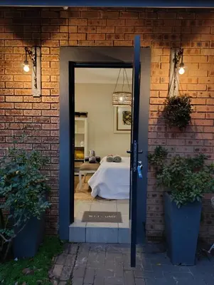 a door leading into a bedroom with a bed at Net 'n Bed in Middelburg
