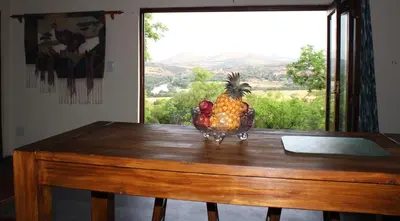 a pineapple statue sitting on top of a wooden table at Oppiberg Cottage with River View in Hartbeespoort