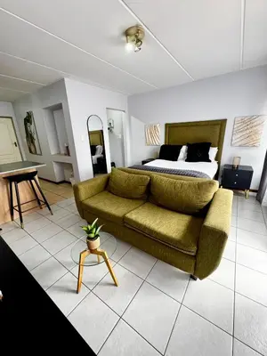 a living room with a couch and a bed at Protea Apartment Midrand in Midrand