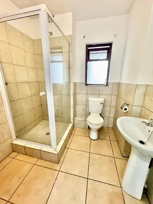 a bathroom with a shower and a toilet and a sink at Protea Apartment Midrand in Midrand