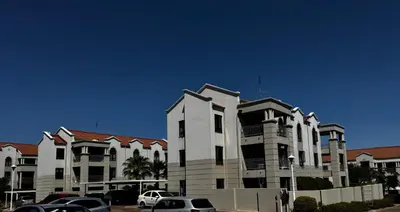 a large building with cars parked in front of it at Protea Apartment Midrand in Midrand