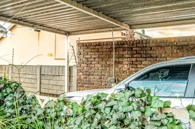 a car parked under a garage with a brick wall at Refresh On Wolseley in Secunda