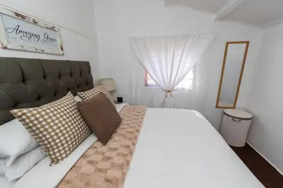 a bedroom with a large white bed and a window at Farmstay at Rehoboth in Benoni