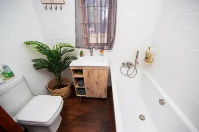a bathroom with a sink and a toilet and a tub at Farmstay at Rehoboth in Benoni
