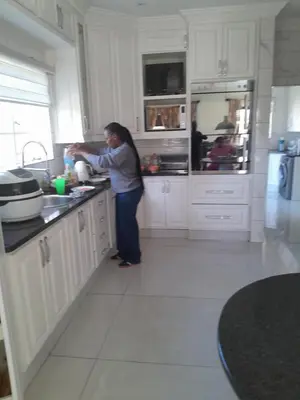 a woman standing in a kitchen preparing food at Prins Albert 6 in Pretoria