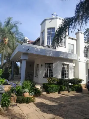 a white house with a palm tree at Prins Albert 6 in Pretoria