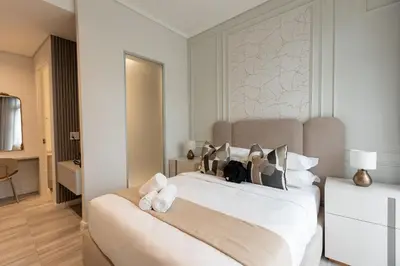 a bedroom with a large white bed with towels on it at 132 Menlyn Maine in Pretoria