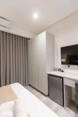 a bedroom with a bed and a desk and a tv at 132 Menlyn Maine in Pretoria