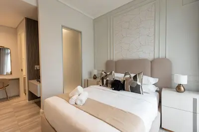 a bedroom with a large white bed with towels on it at 132 Menlyn Maine in Pretoria