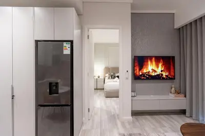 a living room with a fireplace in the wall at 132 Menlyn Maine in Pretoria
