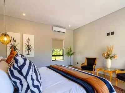 a bedroom with a large bed and a chair at Tenkudu Bush Lodge in Hammanskraal