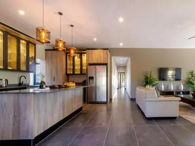 a kitchen and living room with a couch and a counter at Tenkudu Bush Lodge in Hammanskraal