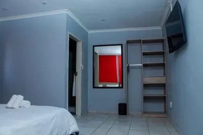 a bedroom with a bed and a mirror and a tv at No 419 Guest House in Midrand