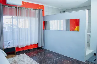 a bedroom with red and white walls and a window at No 419 Guest House in Midrand