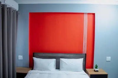 a bed with a red headboard and white pillows at No 419 Guest House in Midrand