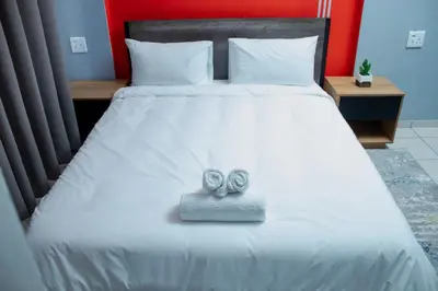a bed with two wedding shoes sitting on it at No 419 Guest House in Midrand