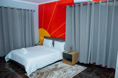 a bedroom with a white bed and a red wall at No 419 Guest House in Midrand