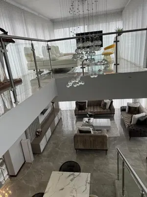 a living room with couches and a staircase at Alimu villa in Nelspruit