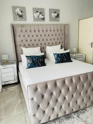 a bedroom with a large bed with a large headboard at Alimu villa in Nelspruit