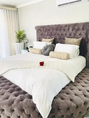 a large bed with white sheets and pillows on it at Alimu villa in Nelspruit