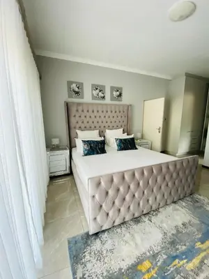 a bedroom with a large bed with a large headboard at Alimu villa in Nelspruit